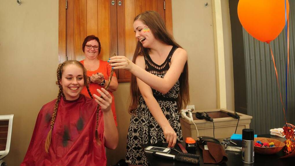  DUBBO: Brittany Mitchell-White takes the first cut of Millie Hicks' hair as she took part in Shave for a Cure on Saturday. Photo: CHERYL BURKE