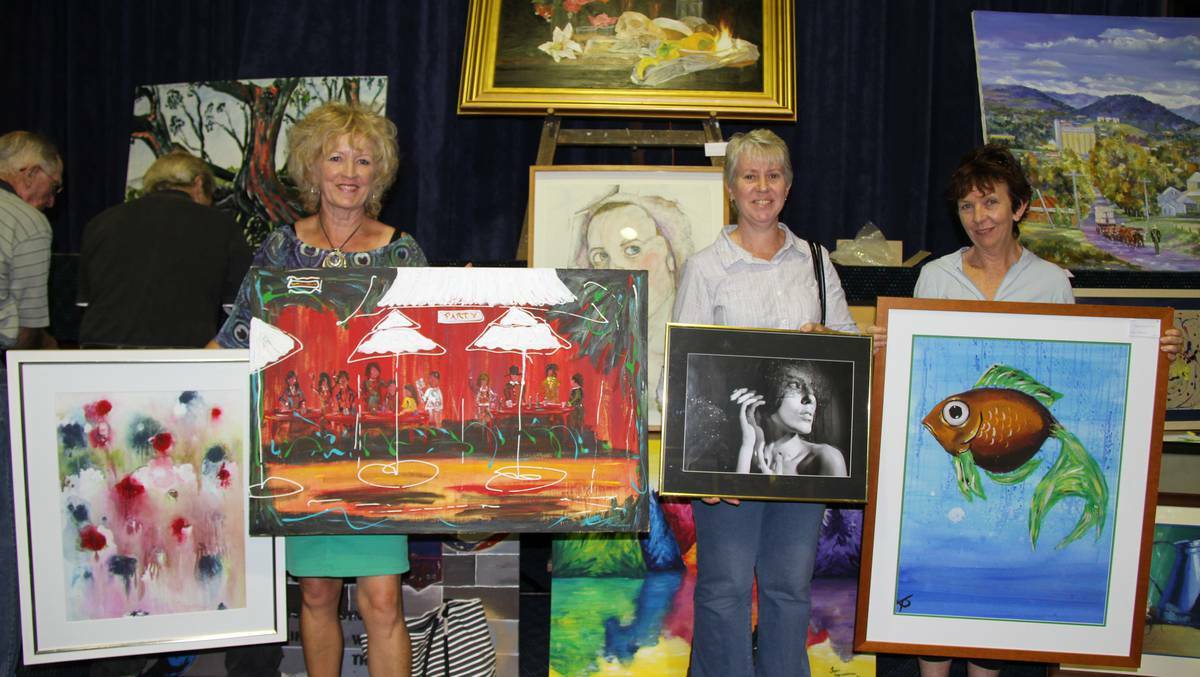 WELLINGTON: Sue Towney, Wendy MacLean and Sharon Tolhurst with some of the paintings attracting interest at the Quota Art Show. 
