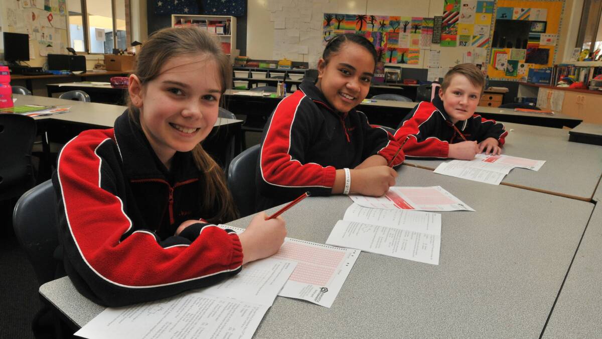 PROBLEM SOLVERS: Micaela Visser, Lesieli Kaufusi and Aidan Smith were among 18,000 year 5 and 6 students to take part in a state wide maths test yesterday. Photo: JUDE KEOGH 0826maths1