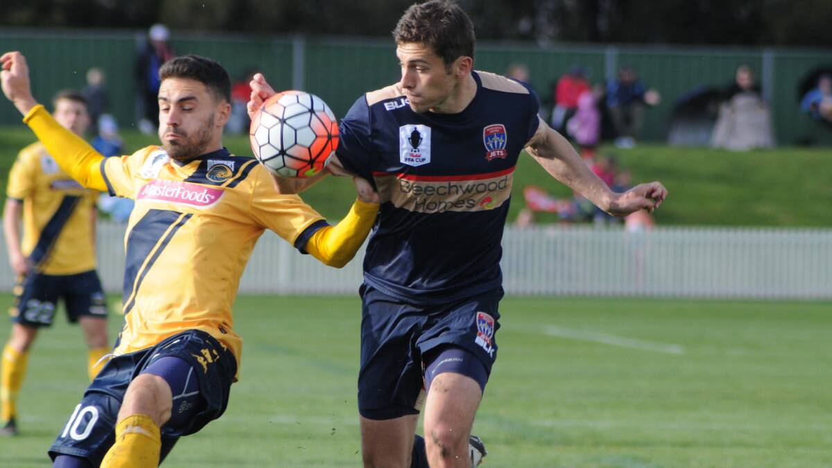 CLOSE QUARTER: Central Coast Mariners Anthony Caceres jostles with Newcastles Mateo Poljak during the A-League pre-season match at Wade Park on September 20. Photo JUDE KEOGH 0920mariners21