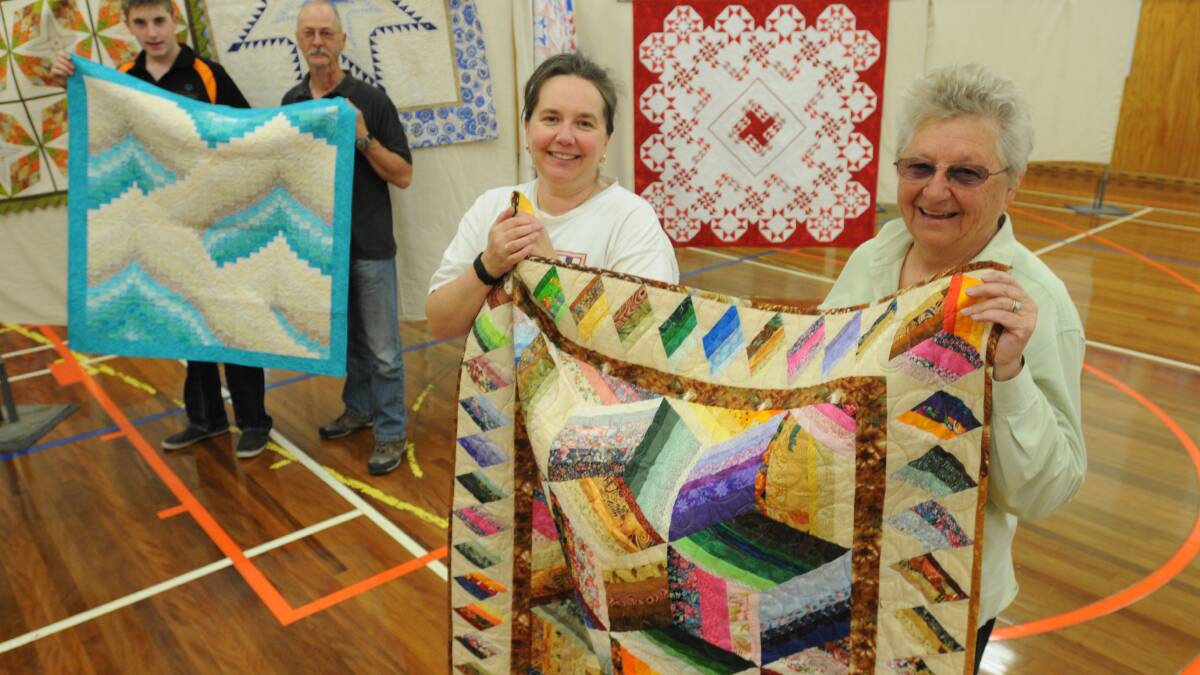 QUILTING TIME: Harry, Terry and Belinda Betts with Ann Visman setting up for today’s quilt show at Canobolas Rural Technology High School.
Photo: STEVE GOSCH 1002sqquilt2
