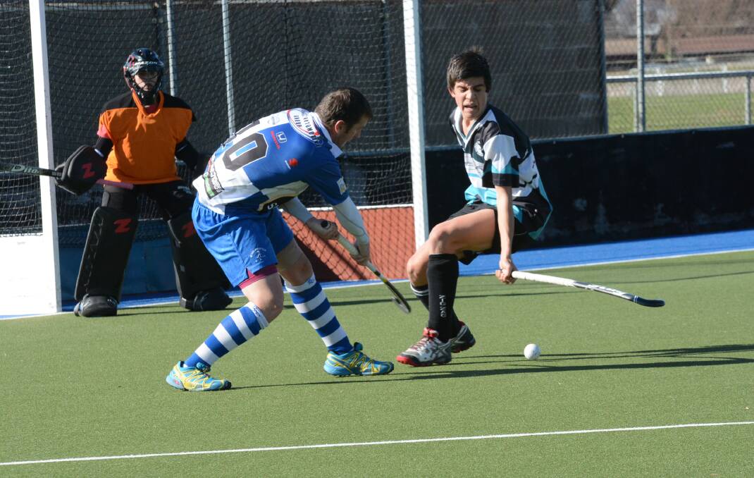 ATTACKING PRESSURE: Saints coach Jaden Ekert fires in a shot under pressure in Saturday’s men’s Premier League Hockey match against Lithgow Zig Zag. Photo: PHILL MURRAY 	072614ppats9