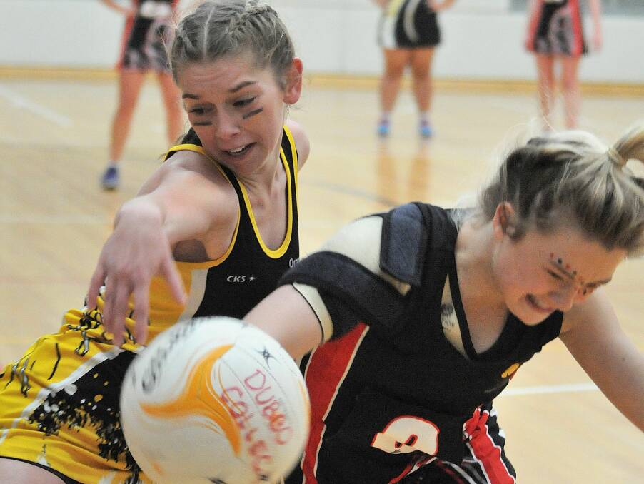 ORANGE ARMY: Opposition centres Alex Kennedy and Majayda Darcy fight for possession in OHS' netball win. Photos: STEVE GOSCH