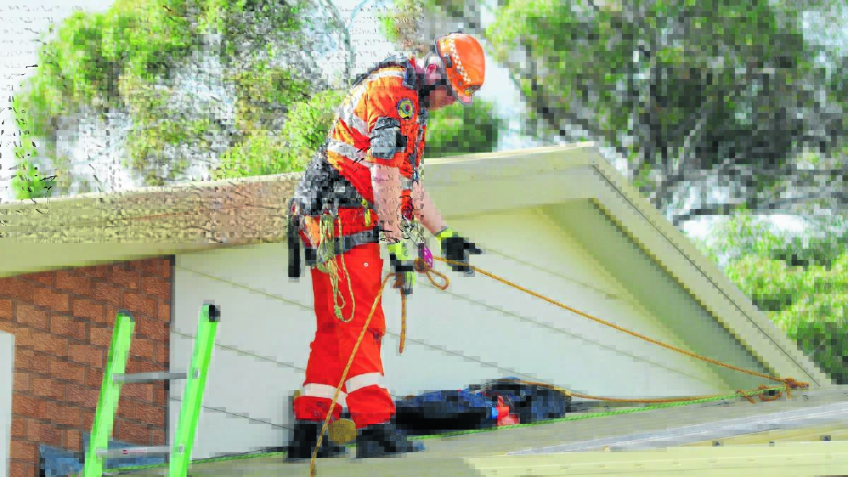 ON TOP: SES deputy team leader Greg Penny climbs a roof during training on Saturday. Photo: STEVE GOSCH 0614sgses
