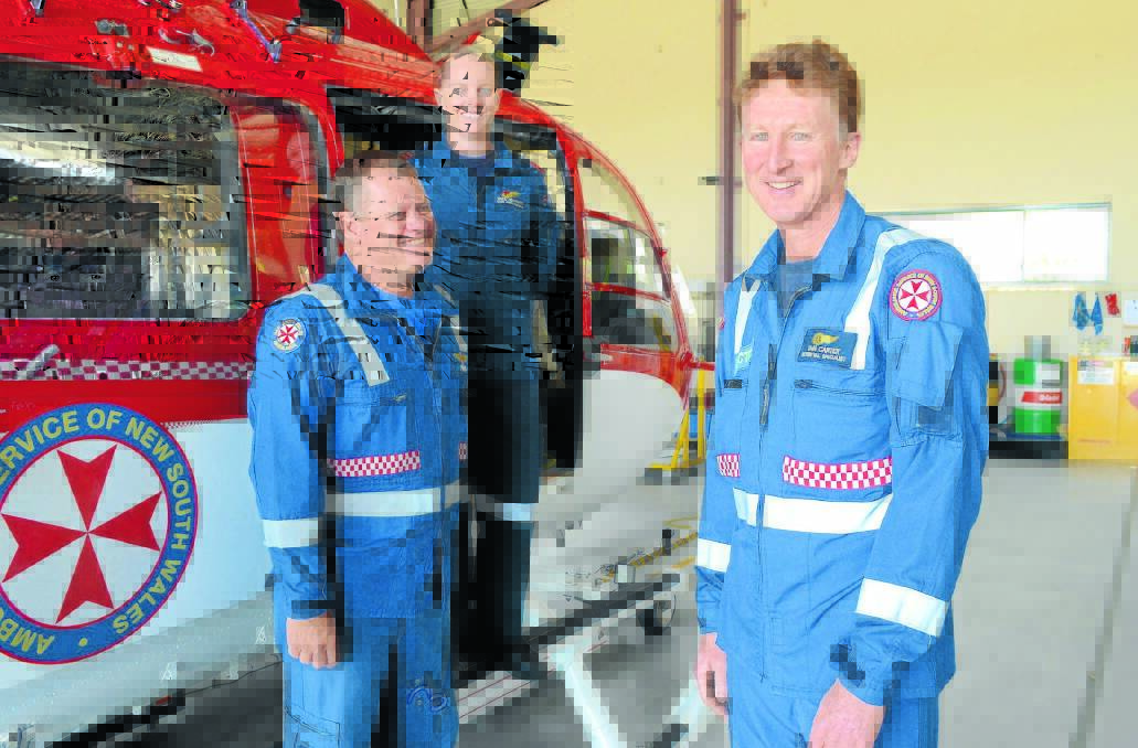 LAST DAY: NSW Ambulance paramedic Mark Ellis and Canadian Helicopter Corporation air crewman Tara Johnson farewell Dr Ian Carter (right) who has spent 20 years working on the Orange-based rescue helicopter. 
Photo: JUDE KEOGH 