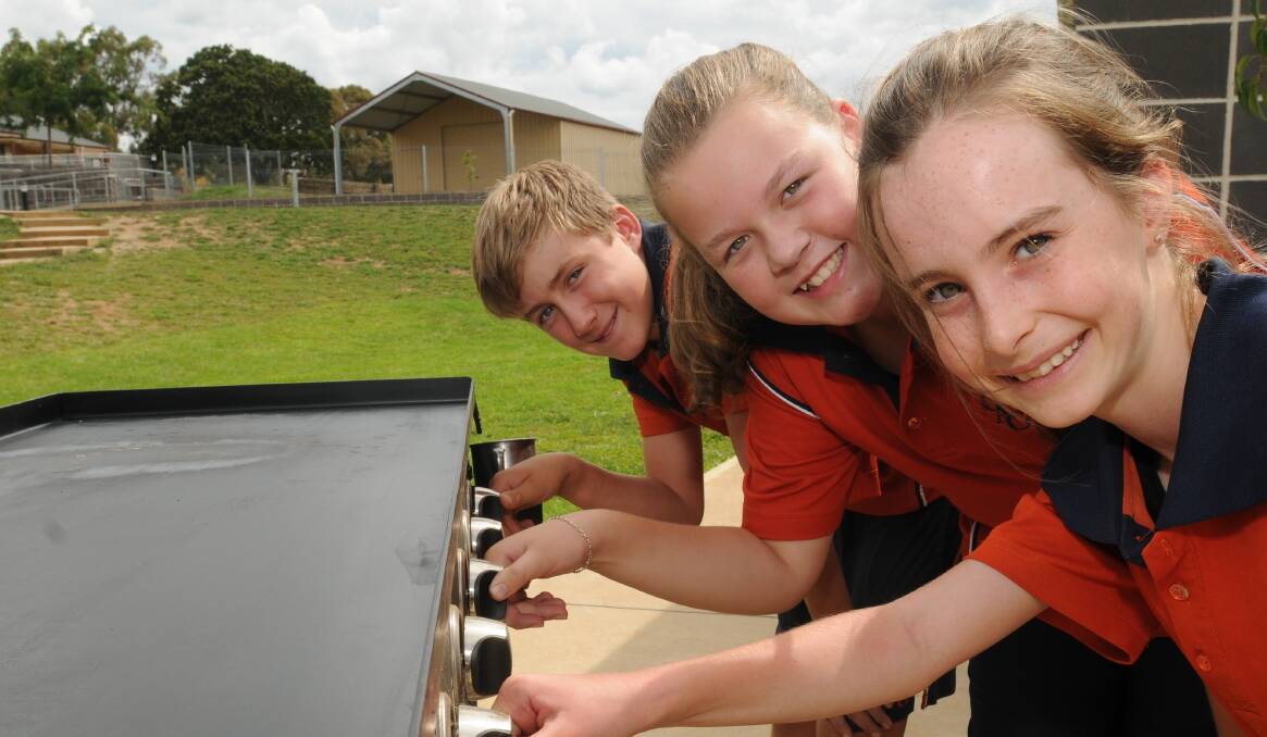 FRY UP FUNDRAISER: Anglian Grammar School students Jackson Willis, Breanna Rouse and Lily Craig are hoping their Friday barbecue will support the Bathurst congregation that lost so much. Photo: STEVE GOSCH 0226sgangli1
