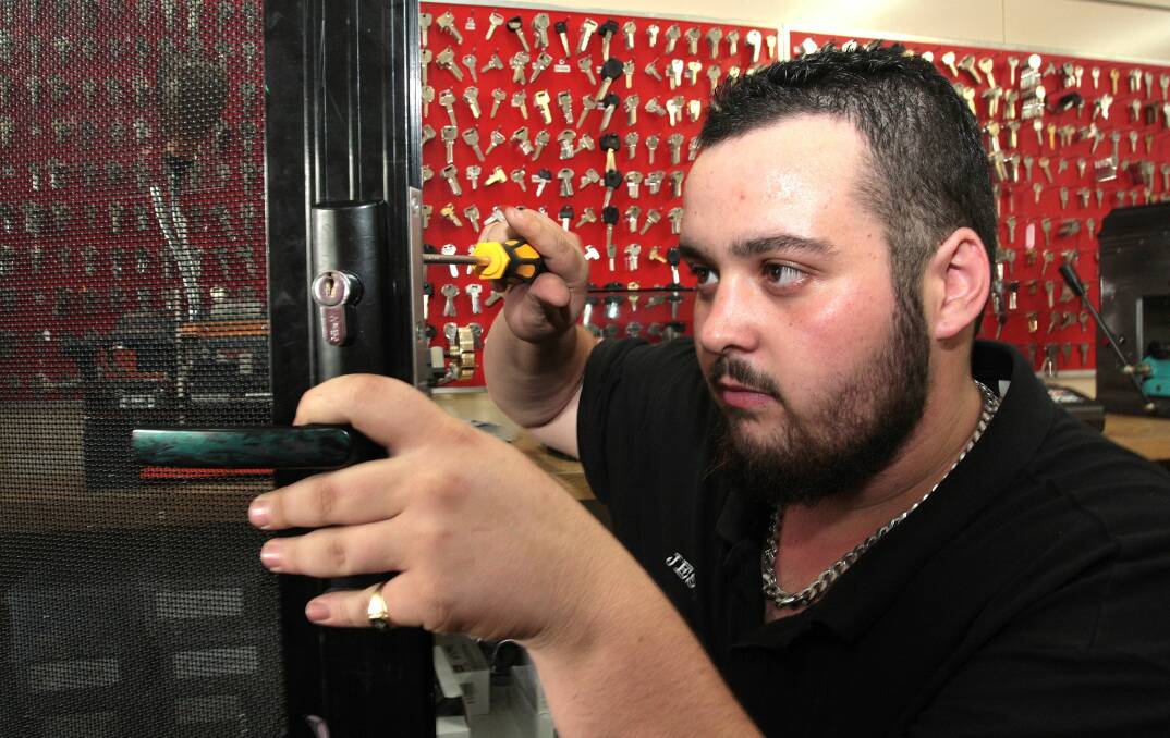  LOCKED UP: Apprentice locksmith Jesse Alpen of Canobolas Locksmiths installing a lock on a security door . Photo: STEVE GOSCH 