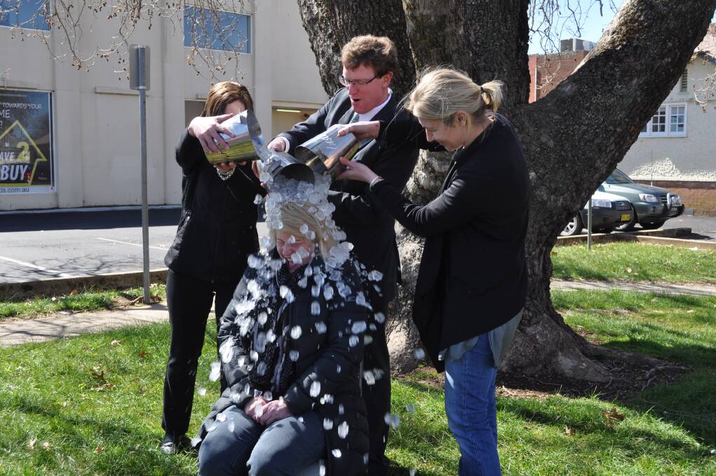 Taste Orange’s Clarissa Lark (left) and Charlotte Gundry (right), and state member for Orange Andrew Gee tipping ice on Rhonda Sear.