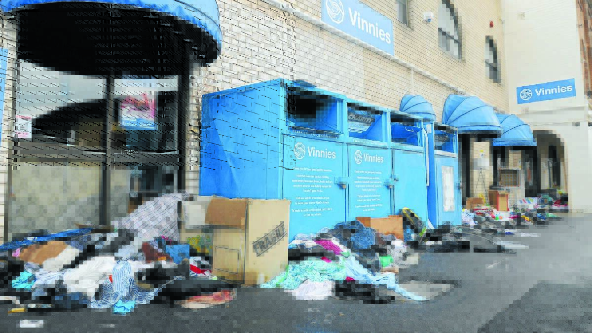 CLEAN-UP: Hundreds of donations were ruined  after people left them next to the charity bins, vulnerable to thieves and the rain. Photo: STEVE GOSCH                                  1228sgvinnies1
