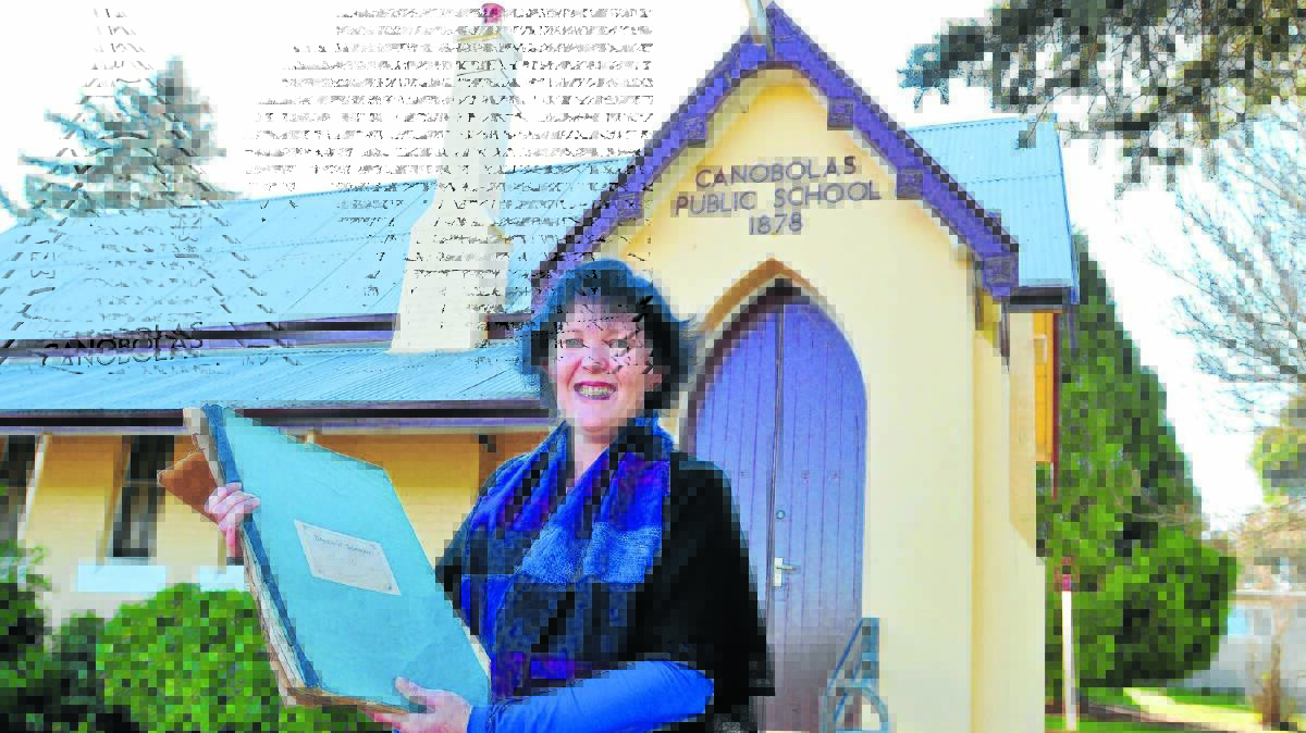 PROUD HERITAGE: Canobolas Public School P&C president Melissa Caulfield with an 1879 register of admission. Mrs Caulfield wants to contact all former students and employees of the school for its 150th anniversary celebrations. Photo: JUDE KEOGH 
