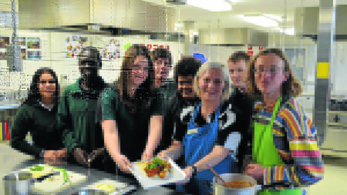 CLASSY MEAL: Canobolas Rural Technology High School students Amber West, Kowag Thit, Macey Starr, Harley Young, Brendon Palmyre, home economics teacher Jennifer Shepherd, student Bryce Rowley and French community member Chris Derrez cannot wait to tuck into the boeuf bourguignon they cooked on Wednesday. Photo: ALEXANDRA KING 0820akfrench
