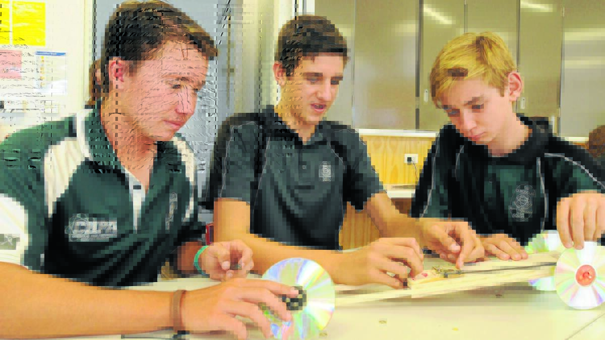 DRIVEN TO SUCCED: Mac Reith-Snare, Matthew Gray and Ben Zegzula built a mousetrap powered dragster on Tuesday as part of a national trial to condense science and technology, engineering and maths into one program. 
Photo: STEVE GOSCH. 
