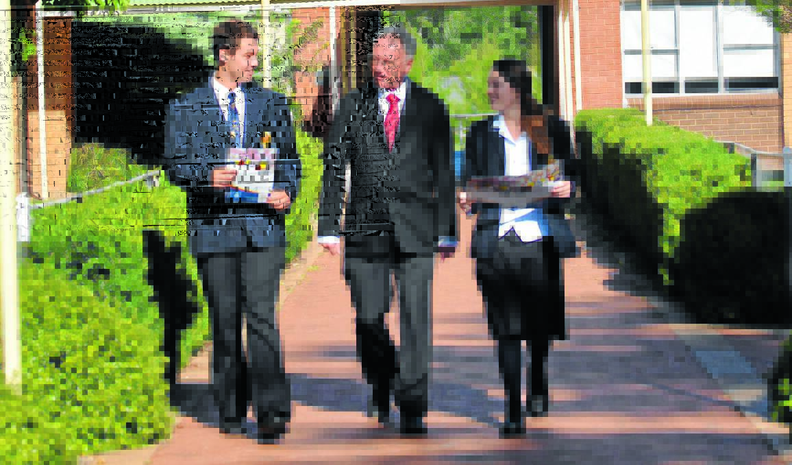 MOVING FORWARD: James Sheahan Catholic High School students Toby West and Tayliah Johnstone are walked through the plan for the next five years at James Sheahan Catholic High School by principal Mark Pauschmann. 
Photo: NICOLE KUTER 0211nksheahan
