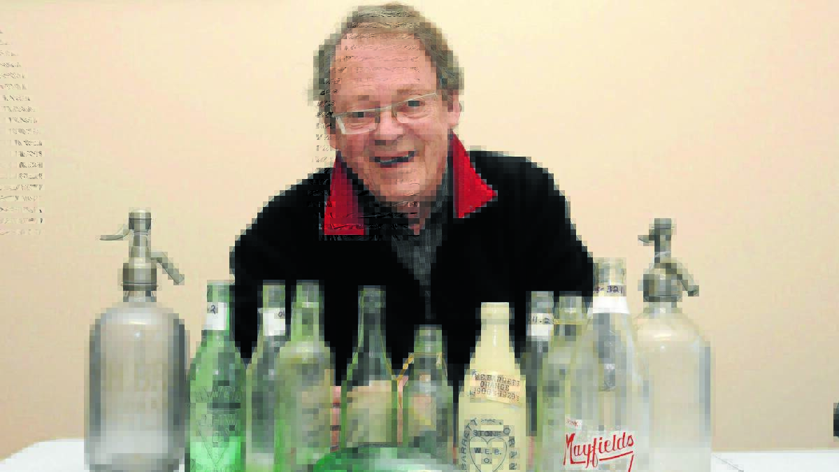 INDUSTRIAL PAST: Orange historian Ross Maroney with bottles from some of Orange’s old cordial factories. Mr Maroney will discuss Orange’s industrial and business past at a casting call for old objects on Saturday. Photo: JUDE KEOGH. 
