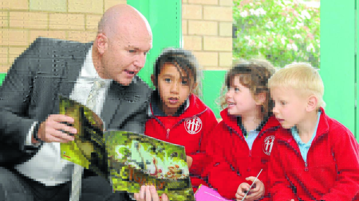 BOOKWORMS IN TRAINING: Newcastle Permanent Charitable Foundation executive officer Jason Bourke with Bowen Public School students Tamia Pollard, Megan Smith and Kane Walker.
Photo: STEVE GOSCH 0620gsbooks1