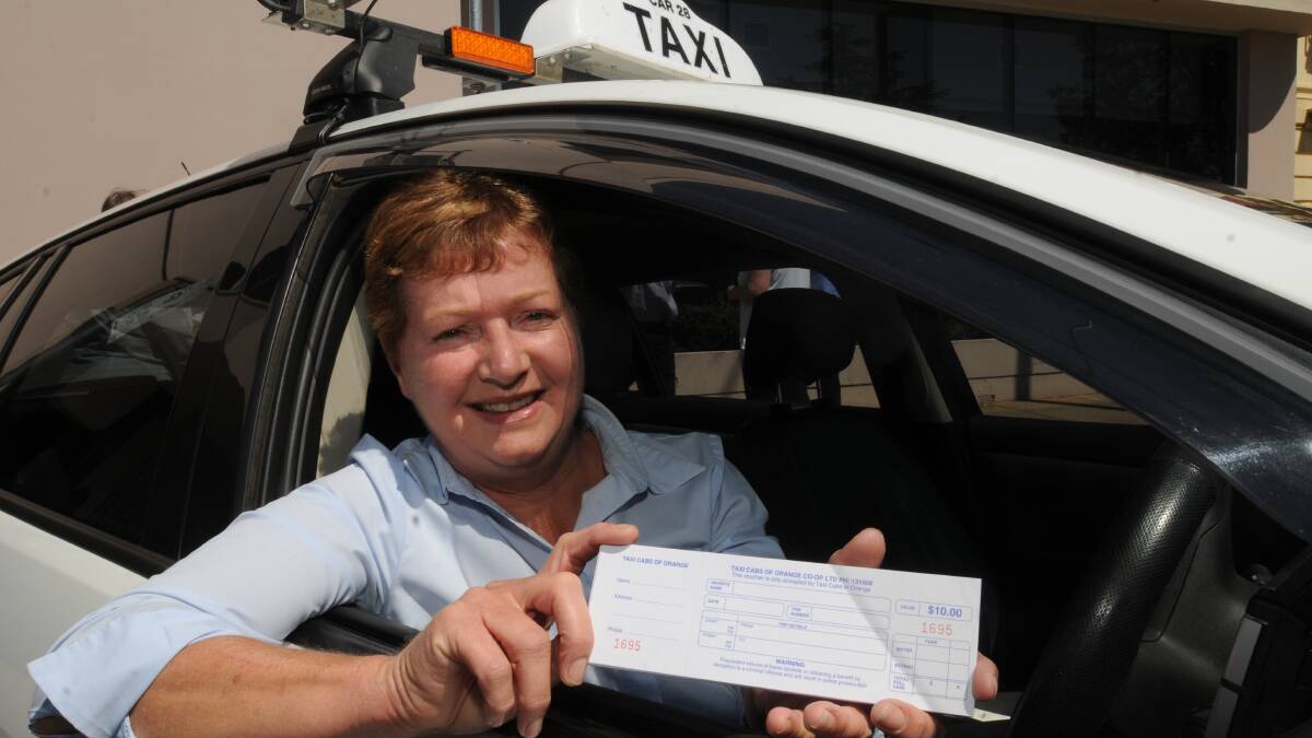 PLAN B: Lyn Phillips of Taxi Cabs of Orange with vouchers on offer for companies who encourage employees to avoid drink-driving after work Christmas parties. Photo: STEVE GOSCH. 1126sgtaxi1