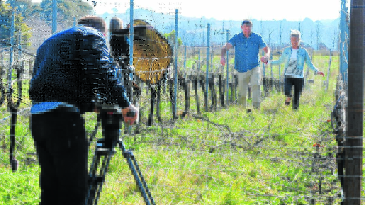 TIPTOE THROUGH THE VINEYARDS: Sydney Weekender cameraman Glen Ellis, producer Susan Elliott and presenters Jason and Bec Stevens hand-in-hand in the vineyards at Racine.
