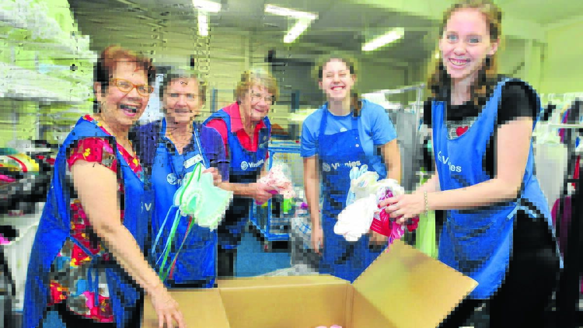ON THE WAY: St Vincent de Paul volunteers Julia Egea, Ann Lane, Margaret Cush with sisters Hannah and Emily Jaques packing one of the final care packages earmarked for the Philippines. Photo: JUDE KEOGH 0218vinnies1