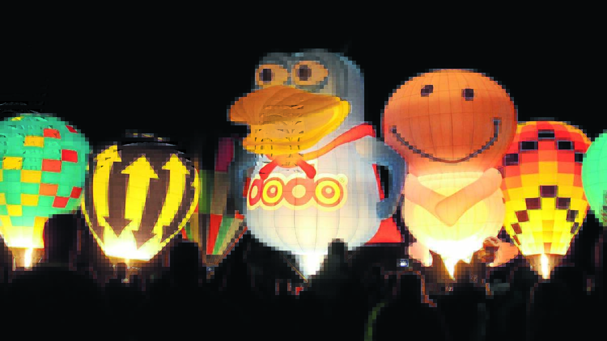 GLOWING REVIEWS: A large crowd gathered in Canowindra on Saturday night to watch the 15 balloons light up the darkness at the Canowindra Balloon Glow and night market. Photo: MICHELLE COOK.
