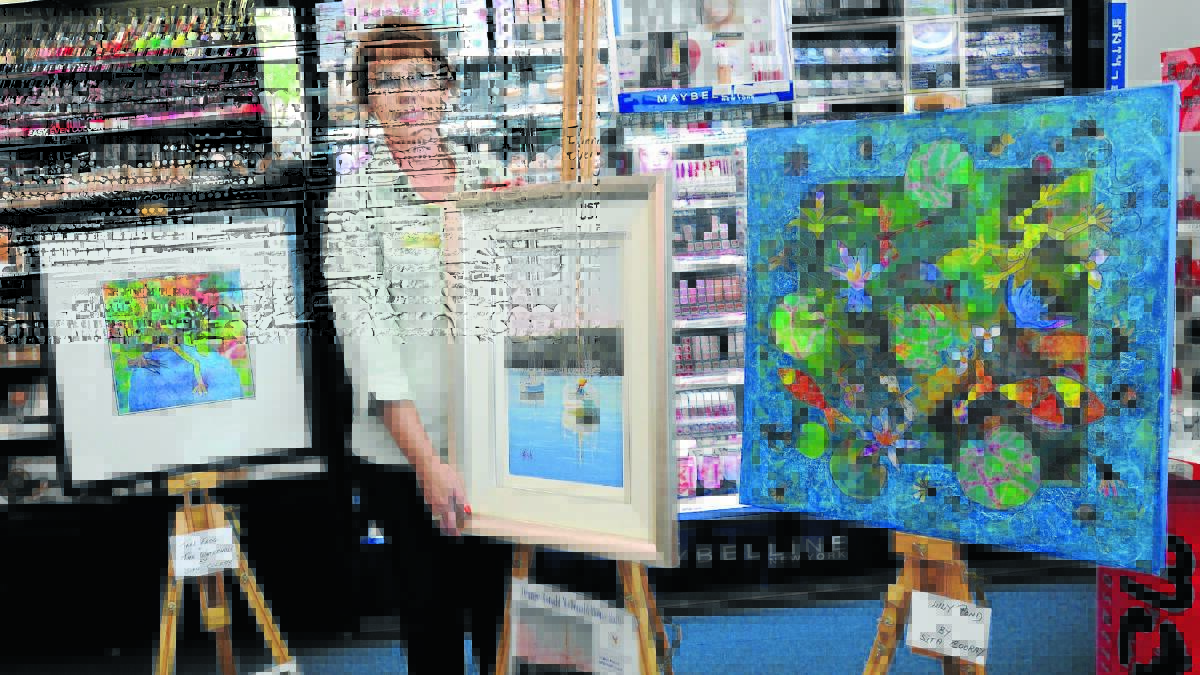 COLOUR YOUR WORLD: Oze Pharmacy retail manager Kerrie Warrington encourages people to walk past the Summer Street store to have a sneak peak at the works to be exhibited. Photo: STEVE GOSCH                                                                                                                                                       0331sgexhibit 

