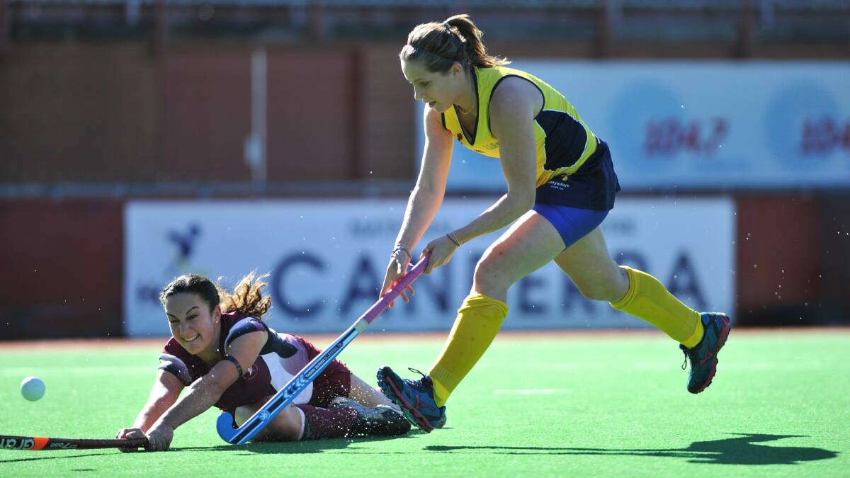 IN THE FIGHT: Orange product Meredith Bone (right) watches Tuggeranong’s Sam Carmichael crash to the ground. Photo: GRAHAM TIDY