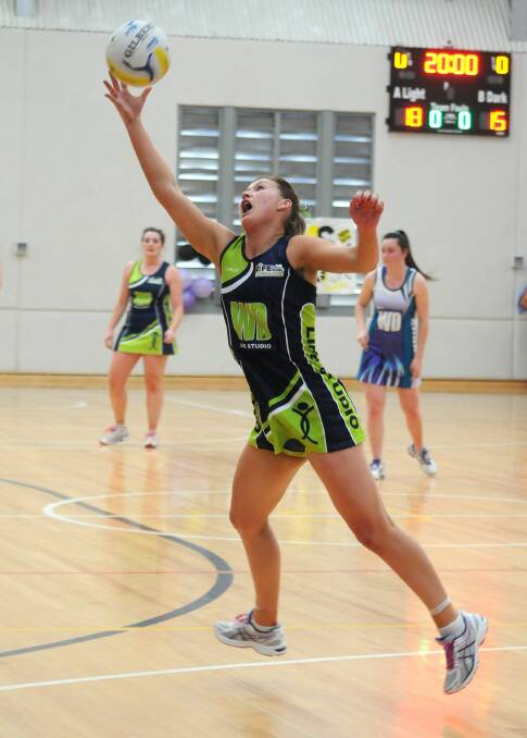 FINGERTIPS: Life Studio's Sophie Beer reaches for the ball in the Orange Netball Association division one grand final. Photo: STEVE GOSCH