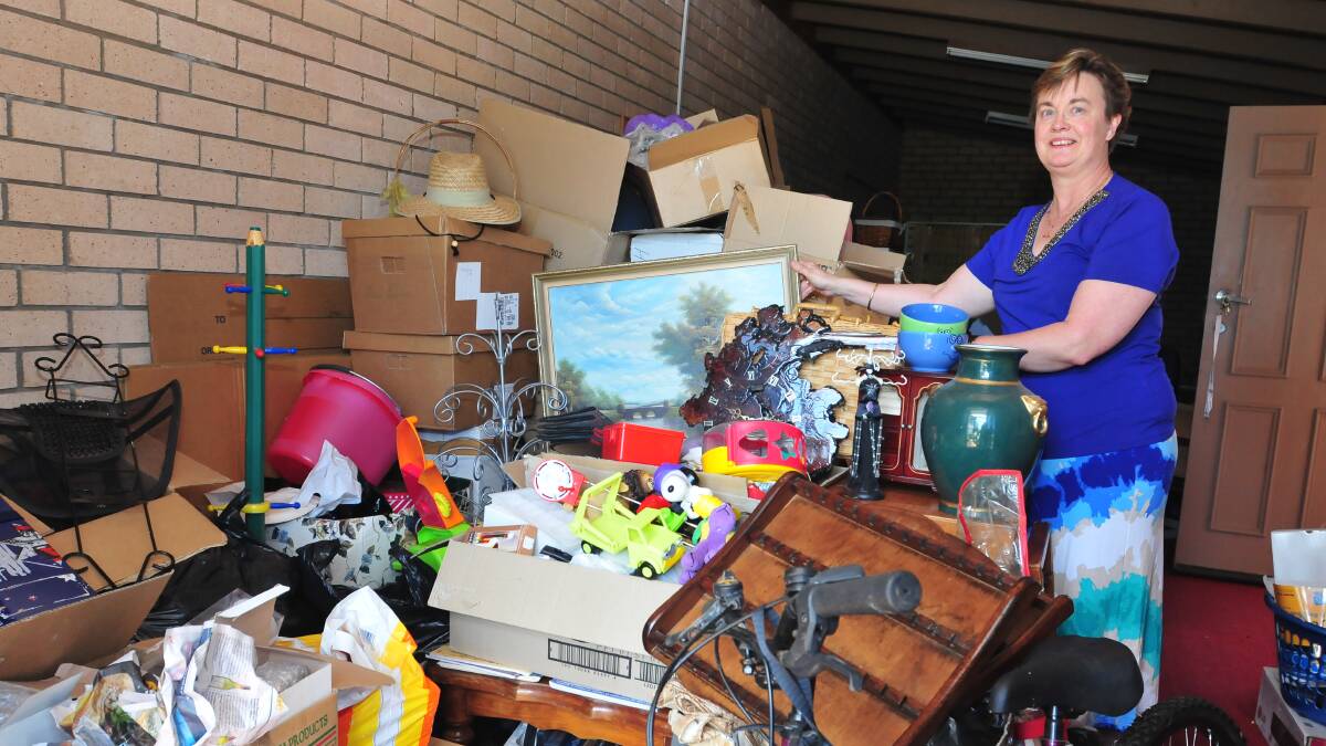 TREASURE TROVE: Robyn Hicks with a selection of items that will be on sale at the Christian Ministry Centre tonight and tomorrow. Photo: JUDE KEOGH 1008garagesale1