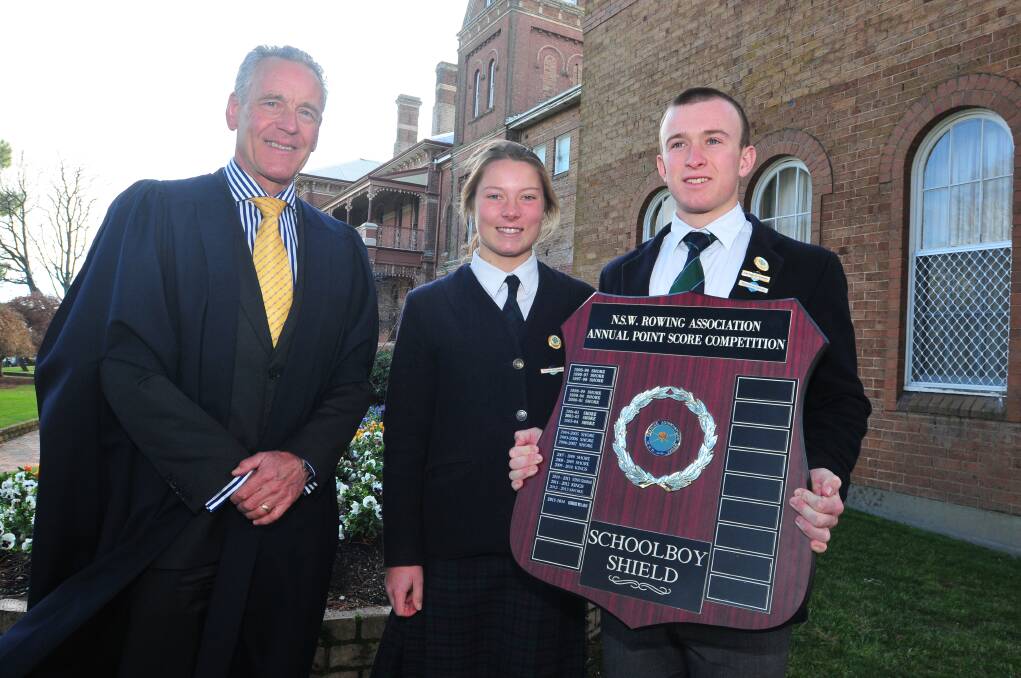 ROW, ROW, ROW YOUR BOAT: KWS rowing captains Nik Thomas (left) and Hugh Alston (right) show off the schoolboy points score trophy with principal Brian Kennelly.
Photo: JUDE KEOGH 0610kwsrowing1