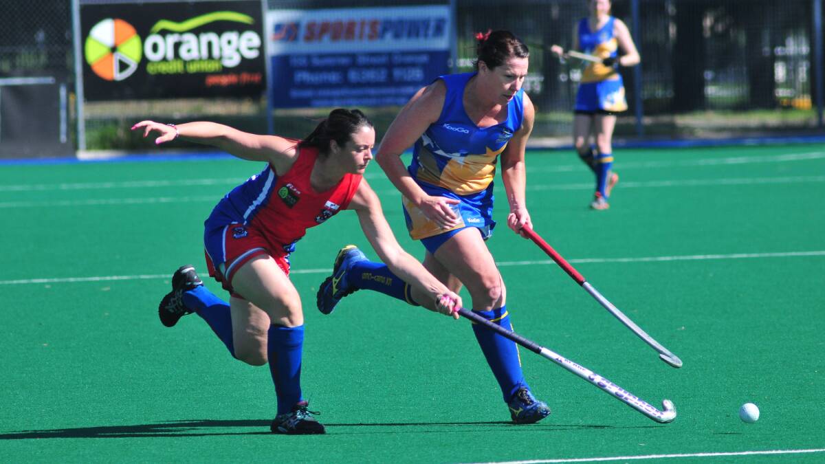 TIGHT CONTEST: Confederates' Lucy Rheinburger (left) challenges Ex-Services' Alison Baker in their women's Premier League Hockey match. Photo: JUDE KEOGH 0412womhock3