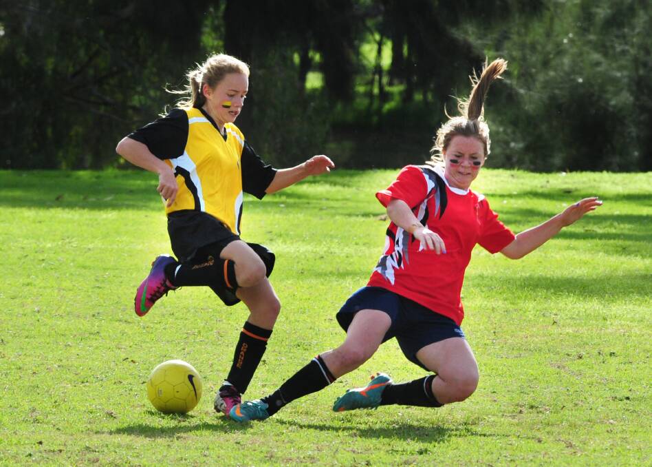 BOOTS AND ALL: Orange High's Emily McDonald (left) tackles Dubbo Senior College's Jessica Fuller in their Astley Cup girls' football match. Photo: LOUISE DONGES
