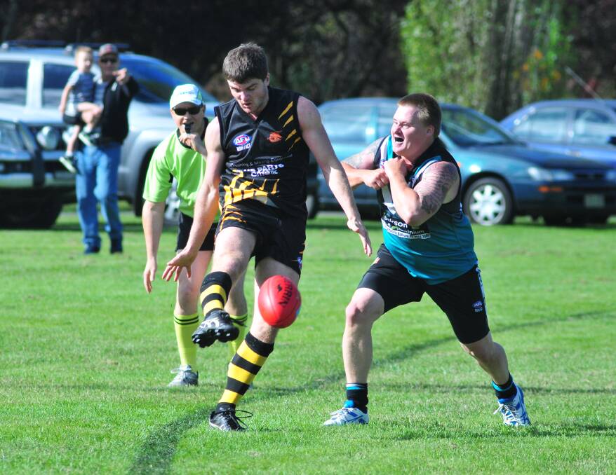 LOOK OUT: Orange Tigers' Daniel Bruce gets the ball away before a Bathurst Bushrangers player charges in their Central West AFL match. Photo: JUDE KEOGH                                                                                         0412afl10