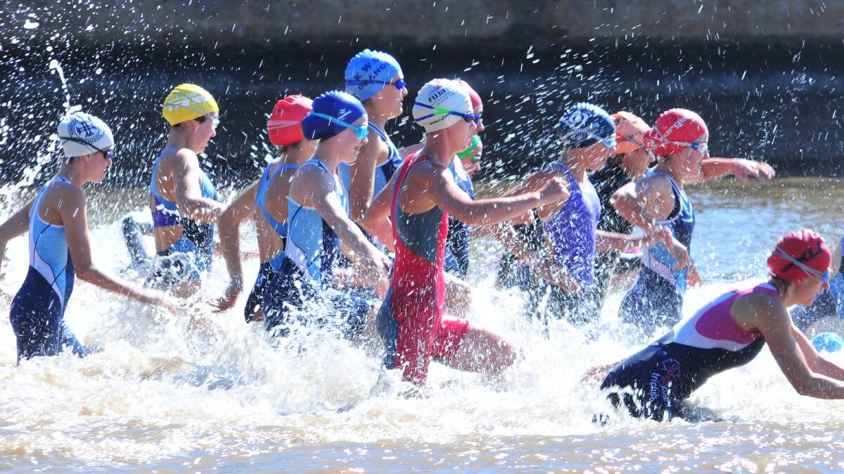 GETTING WET: The ladies start the swim leg at Lake Canobolas. Photo: JUDE KEOGH 0209tri4