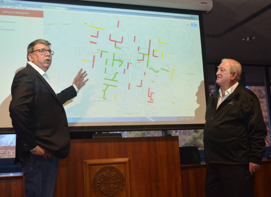 PLAN OF ATTACK: Councillor Glenn Taylor and mayor John Davis review a map of the footpath upgrade work scheduled for the next four years. Photo: DECLAN RURENGA 0728drpaths1