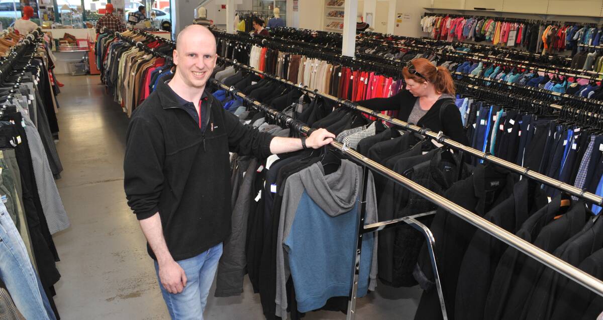 KEEP WARM: Salvation Army store manager Richard Norman with one of the few items of winter clothes left. The Salvos area appealing for more. Photo: Jude Keogh 0629jksalvos2