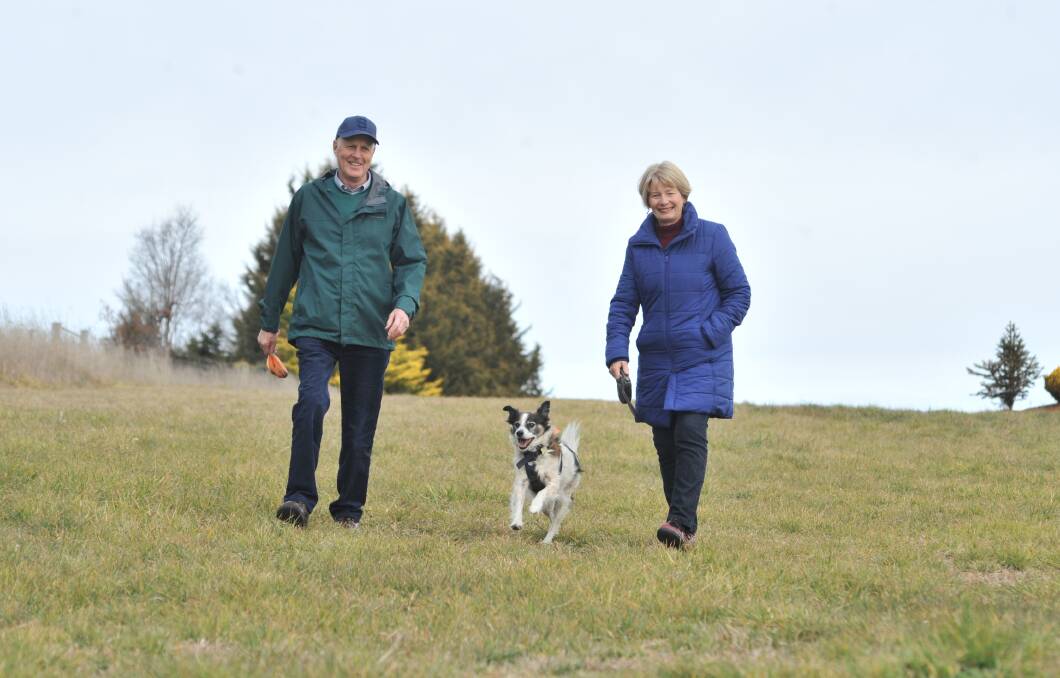 LOOK AT ME GO: Rex bounds around the city's latest off-leash area off Lombardy Way with owners Neil and Libby Jones. Photo: JUDE KEOGH 0811jkdogs3