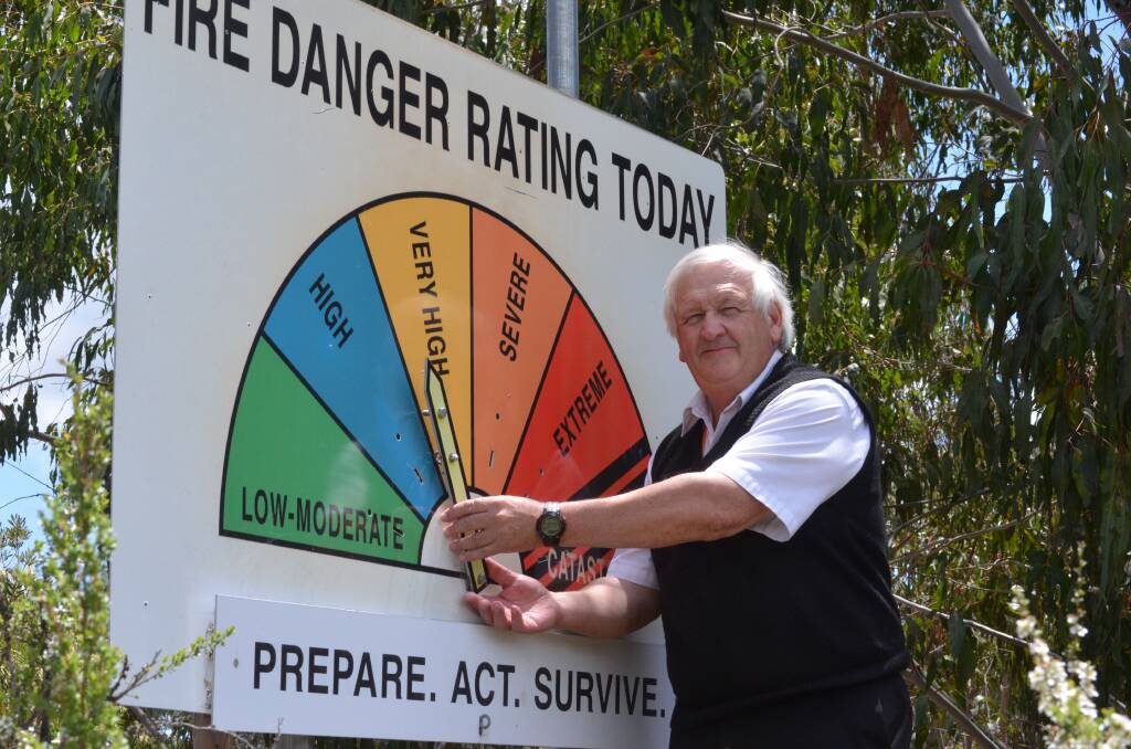PREPARE: RFS Canobolas Zone technical officer Geoff Selwood adjusts a fire danger rating warning sign on Wednesday. Photo: DECLAN RURENGA 1122drrating2