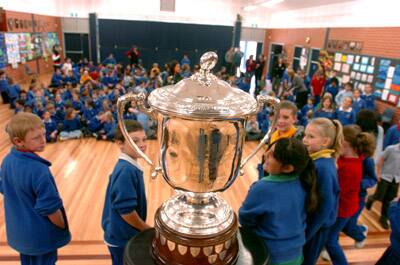 CENTRE OF ATTENTION: Students at Bletchington Public School get up close and personal with the Bledisloe Cup on Tuesday.