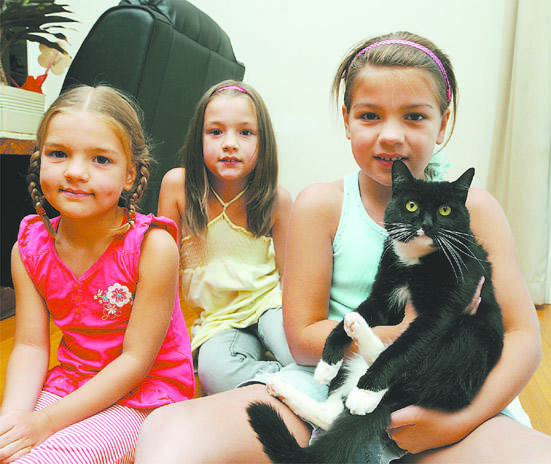 SHOCKED: Olivia, Annie and Jessie Goodlock with Sox, who went missing and was found with no claws last week.