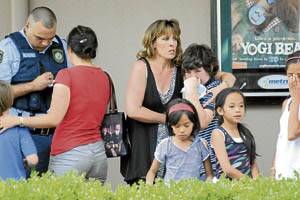 DISTRESSED: The strain of the situation at Bathurst’s Metro Cinemas yesterday was etched on the face of resident Debbie Gardiner (centre) as she comforted a distraught child.