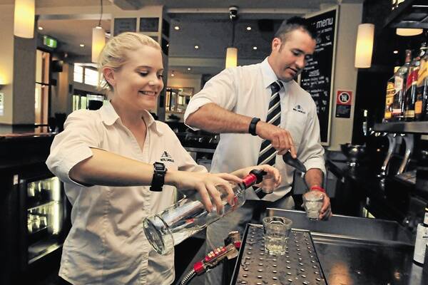 ENERGY KICKS: Hotel Canobolas employees Chloe Raines and Aaron Hansen pour beverages at Hotel Canobolas, which does not sell high energy drinks.