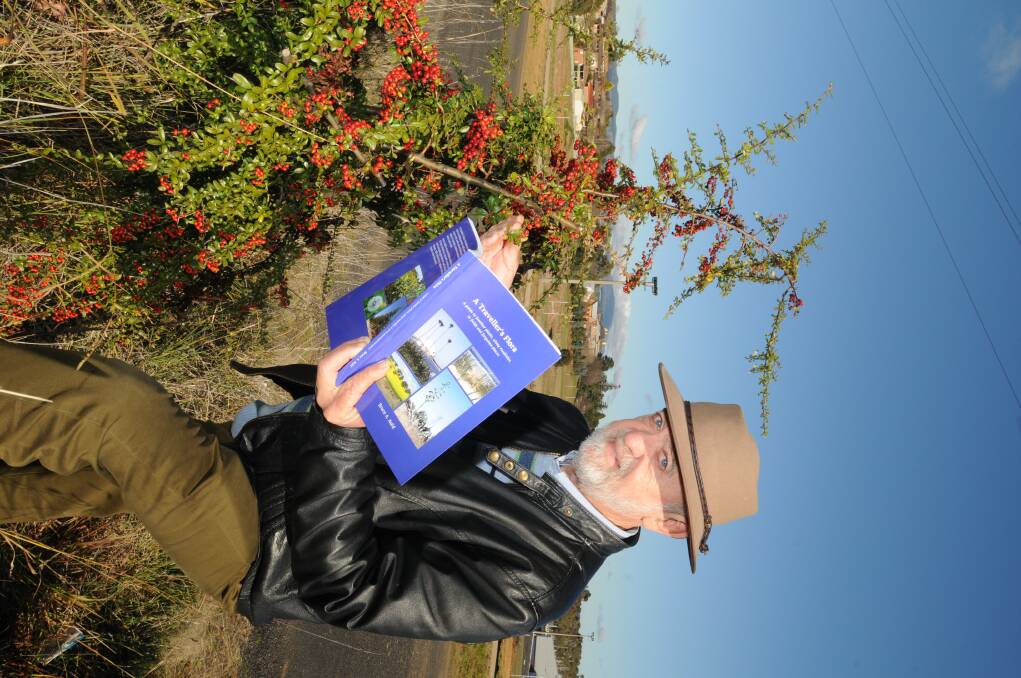 TRAVEL COMPANION: Borenore author Bruce Auld with his new book A Traveller's Flora which he said will be a great travel companion, he is pictured with a colourful firethorn bush. photo: STEVE GOSCH 0704sgbruce2