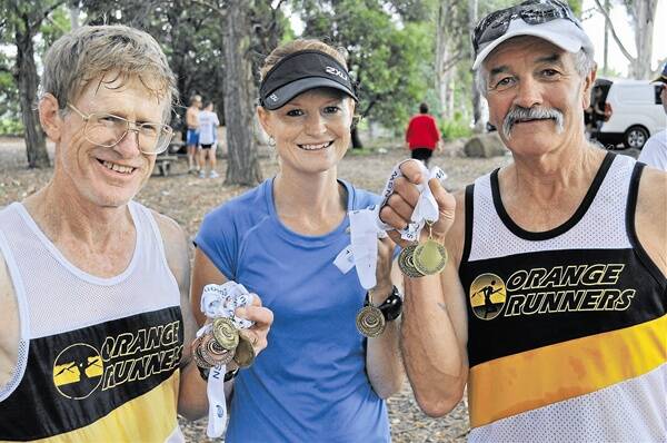 SWAG OF MEDALS: Orange Runners Club members (from left) John West, Carrie Williamson and Jim Rich performed well at the NSW Country Track and Field Championships.            Photo: NICK McGRATH 0201nmrunners1
