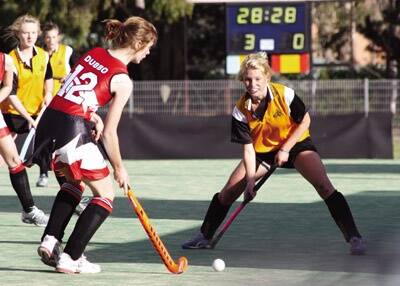 ON THE MOVE: Dubbo Senior College’s Emily Ainsworth moves the ball forward as Orange High’s Kate Butcherine lines up in defence. Orange High easily claimed the Astley Cup hockey game 5-nil yesterday with Butcherine and Rachel Divall scoring two goals each.