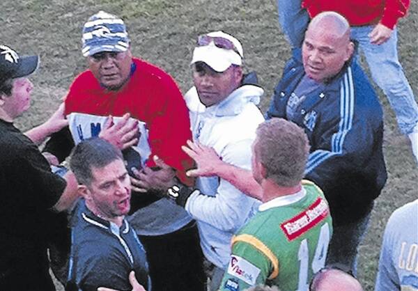GUILTY: Heamoni Fangu Fangu (red top) is restrained after assaulting the referee at the Orange Group 10 local derby on July 30.