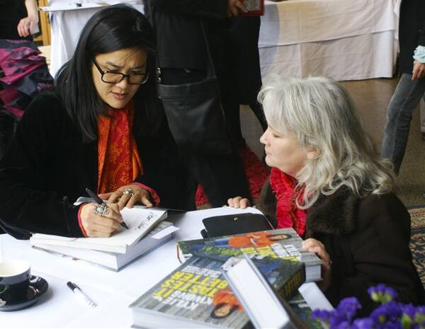 ETHICAL EATING:  Kylie Kwong signs copies of her new book while chatting with old school friend Julia Hobbs yesterday. Photo: MARK LOGAN              0702kylie2