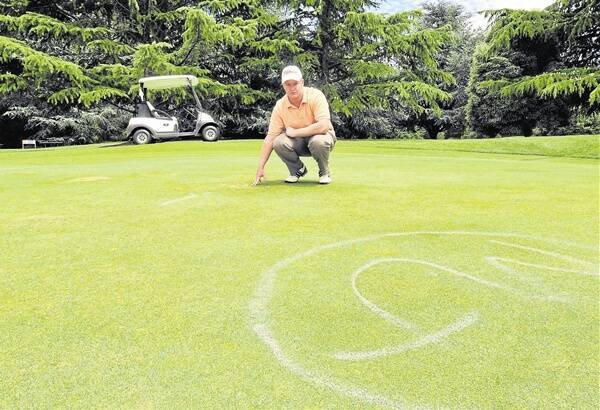 A HOLE IN TWO: Wentworth staff member Trav Roweth on the damaged fourth green, one of two attacked by vandals on Monday night. Photo: JUDE KEOGH        0110wenty1