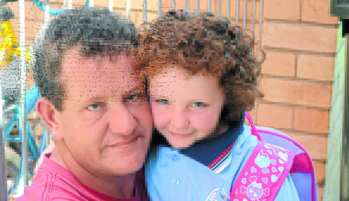 DADDY’S GIRL: Morgan Nugent gives his daughter Shelby-Rose a big hug after her first day at Bowen Public School. Photo: NICOLE KUTER 			        0131nkbowen1