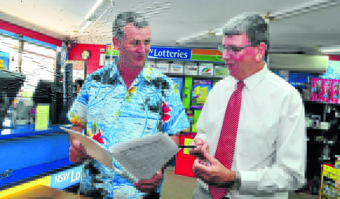 SIGN HERE: Greengate Newsagency owner Stephen Parker and councillor Glenn Taylor were the first to sign the petition to push for more paramedics for Orange. 														     Photo: JUDE KEOGH 0218petition3