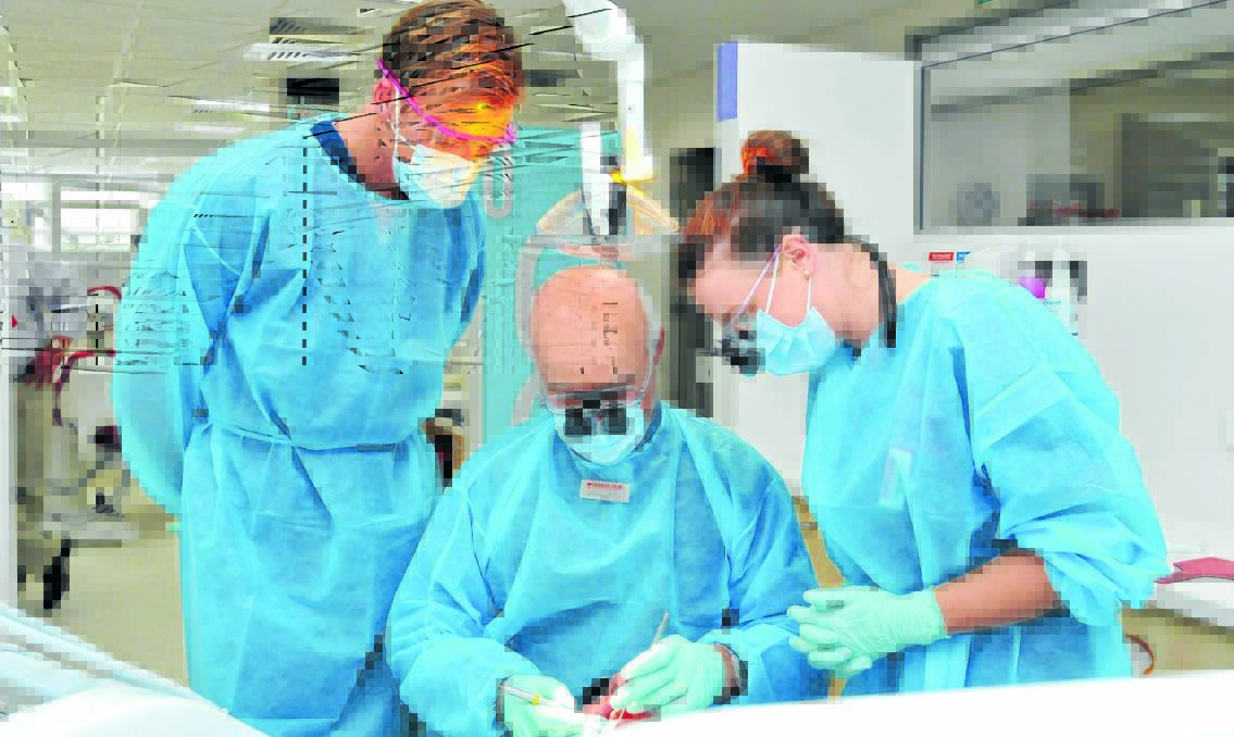ROOT CAUSE: Dental student Kristie-Lee Anning gets tutoring from Dr Edward Furze with help from Paschal Grenquist during a clinic at Charles Sturt University. Photo: JUDE KEOGH                                                                                                                                                           0508students3