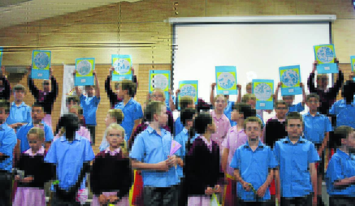ASIAN CENTURY: Year 3 students at St Mary’s Catholic Primary School show off their Asian artworks at a ceremony at the school yesterday. Photo: NICOLE KUTER  1112nkasia 